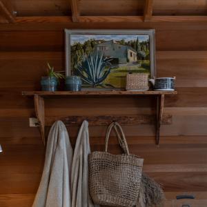 a shelf with a framed picture on a wall with towels at Orion Treehouses in Saint Paul de Vence