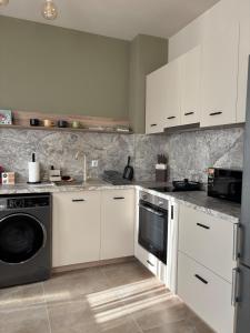 a kitchen with white cabinets and a dishwasher at Apartment Dragoman 10 in Pleven +13 photos