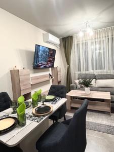 a living room with a table and chairs and a couch at Apartment Dragoman 10 in Pleven