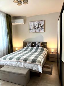 a bedroom with a bed with a checkered blanket at Apartment Dragoman 10 in Pleven