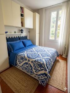 a bedroom with a blue and white bed with a window at La casa di Giò in Varazze +5 photos