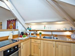a kitchen with wooden cabinets and a sink at Tuckenhay, Coomberry Loft - Fcp in Ashsprington +31 photos