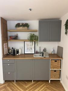 a kitchen with gray cabinets and a sink at The Summerhouse in Cheadle