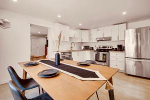 a kitchen with a wooden table with chairs and a refrigerator at Laurier Suites in Gatineau