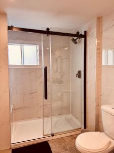 a shower stall in a bathroom with a toilet at Laurier Suites in Gatineau