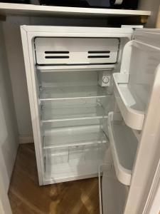 an empty refrigerator with its door open in a kitchen at The Summerhouse in Cheadle