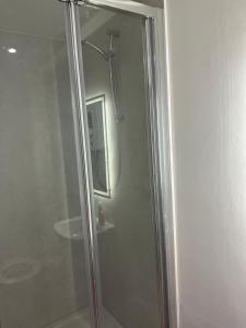 a shower with a glass door in a bathroom at The Summerhouse in Cheadle +9 photos