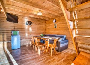 a dining room with a couch and a table in a cabin at Domki u Henia i Anety in Werlas