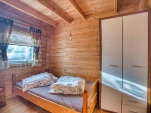 a small room with a bed in a wooden cabin at Domki u Henia i Anety in Werlas