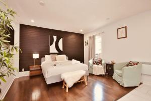 a bedroom with a large bed and two chairs at Laurier Suites in Gatineau