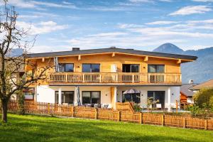 a large house with a wooden fence in a yard at ViVaZILARE - Design Loft with Terrace in Fügen