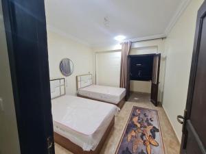a small room with two beds and a window at Fatah Apartment 13 in Luxor