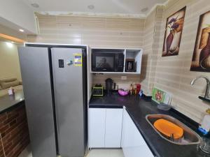 a kitchen with a refrigerator and a sink at Fatah Apartment 13 in Luxor