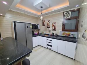 a kitchen with a black counter top and a refrigerator at Fatah Apartment 13 in Luxor