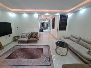 a living room with couches and a flat screen tv at Fatah Apartment 13 in Luxor +6 photos