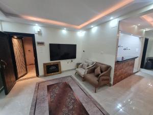 a living room with a chair and a television at Fatah Apartment 13 in Luxor