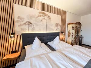 a bedroom with a large bed with two white pillows at Hotel Berghof in Hellenthal