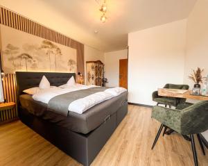 a bedroom with a bed and a desk and a chair at Hotel Berghof in Hellenthal