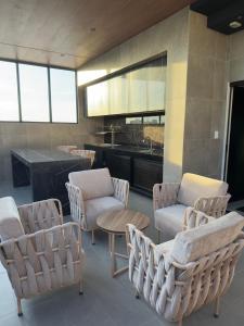 a room with chairs and a table and a kitchen at Serenity Loft - Confort, Relax y Buena Ubicación in Santa Cruz de la Sierra +2 photos