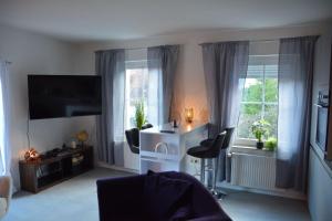 a living room with a tv and two windows at Zur Eresburg in Marsberg