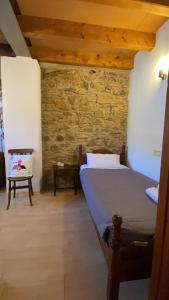 a bedroom with a bed and a stone wall at Allotjaments rurals Can Punti in Vallfogona de Ripolles