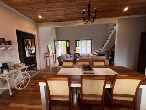 a dining room and living room with a table and chairs at Hospedaria Casa Verde in Itapoa