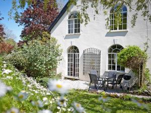 a white house with a table and chairs in the yard at Tuckenhay, Clock Tower Cottage - Fjg in Ashsprington