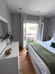 a bedroom with a large bed and a balcony at Curros in Ponte Do Porto