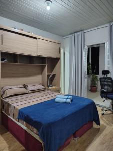 a bedroom with a large bed with a blue blanket at Chico's House in Uruguaiana