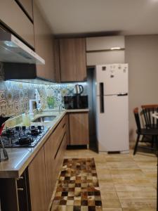 a kitchen with a stove and a refrigerator at Chico's House in Uruguaiana +23 photos