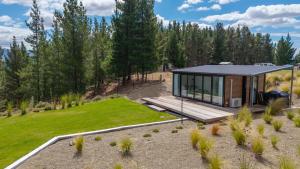 a small cabin with a deck and a lawn at Modern studio overlooking Alexandra, Central Otago in Alexandra
