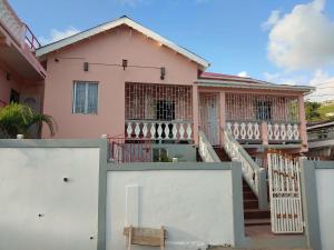 a pink house with a white fence at Vincy vybz in Kingstown
