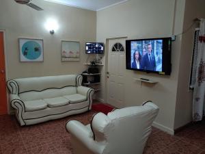 a living room with two white couches and a flat screen tv at Vincy vybz in Kingstown