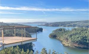 a suspension bridge over a river with trees and forests at Curros in Ponte Do Porto