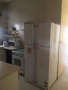 a kitchen with a white refrigerator and a stove at Fatah Apartment 14 in Luxor