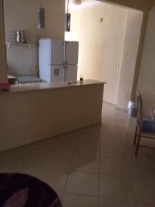 a kitchen with a counter with a refrigerator at Fatah Apartment 14 in Luxor