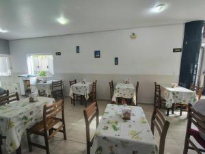 ein Esszimmer mit Tischen und Stühlen mit weißen Tischdecken in der Unterkunft Avila Hotel in Boa Esperança