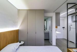 a bedroom with a white bed and a bathroom at Studio - Quaddra Butantã NOVÍSSIMO MODERNO - Academia - Piscina - 5min Metrô e USP in São Paulo +29 photos