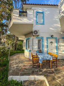 a table and chairs in front of a house at Olive Grove House in Kámpos