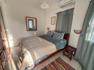 a small bedroom with a bed and a mirror at Olive Grove House in Kámpos