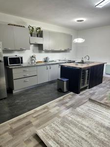 a large kitchen with white cabinets and a counter at Fabrizio house in Timişoara