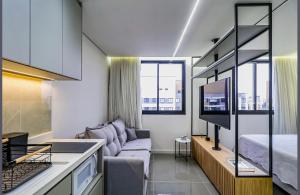 a living room with a couch and a tv and a bed at Studio - Quaddra Butantã NOVÍSSIMO MODERNO - Academia - Piscina - 5min Metrô e USP in São Paulo