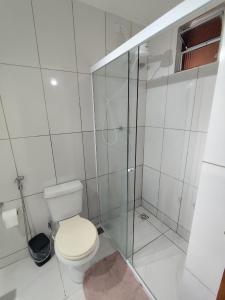 a white bathroom with a toilet and a shower at Microcasa com ar em Resende in Resende