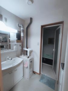 a white bathroom with a sink and a mirror at Moio Homestay in Sapporo +24 photos