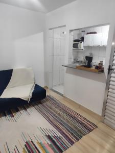 a living room with a rug and a kitchen at Microcasa com ar em Resende in Resende