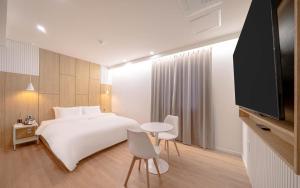 a hotel room with a bed and a flat screen tv at 스테이 공담호텔 in Kyū-masan