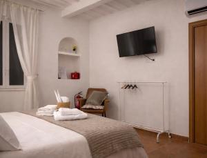 a bedroom with a bed with a flat screen tv on the wall at Little Medieval House Nettuno in Nettuno