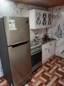 a kitchen with a refrigerator and a stove at Refugio Rancagua in Pueblo de Naturales +2 photos