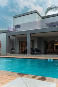 a house with a swimming pool in front of it at Tlou Luxe stay in Gaborone