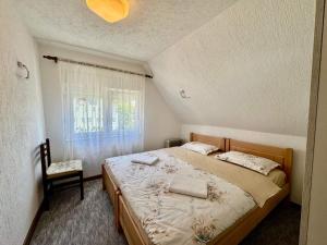 a bedroom with a bed and a chair and a window at Planinski vuk rooms in Žabljak +14 photos